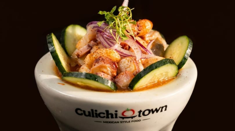 Culichitown Mexican-style food: a white bowl of ceviche with shrimp, octopus, red onion, and cucumber.